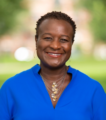 Woman smiling in a blue shirt and a necklace