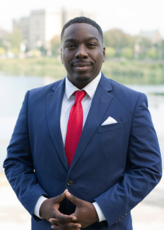 Man in suit standing in front of water