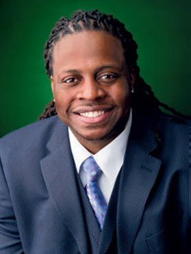 Dr. Keith Lezama '07 smiling in a suit and tie.